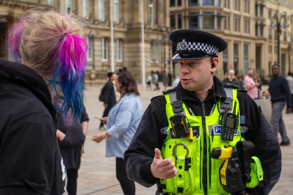 Pioneering neurodiversity training for Met police officers launched A protester with coloured hair speaks to a Police Sergeant