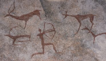 Figure animals and hunter on the stone wall of the cave paint ocher ancient prehistoric Neanderthal. prehistoric animal, stone age hunting for deer
